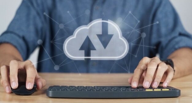 A man sits at a keyboard with a cloud logo in the foreground