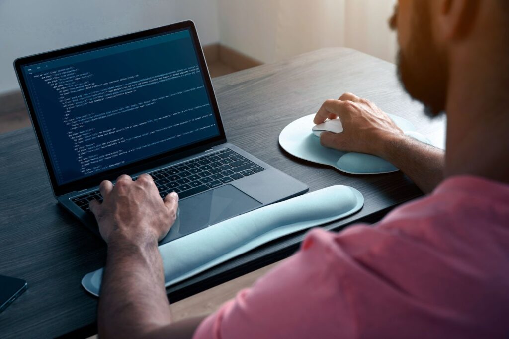 Man working on laptop with code